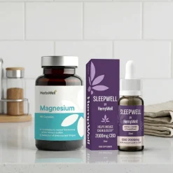 Magnesium supplement bottle with teal label beside SleepWell CBD products on a kitchen counter with a white tile backsplash.